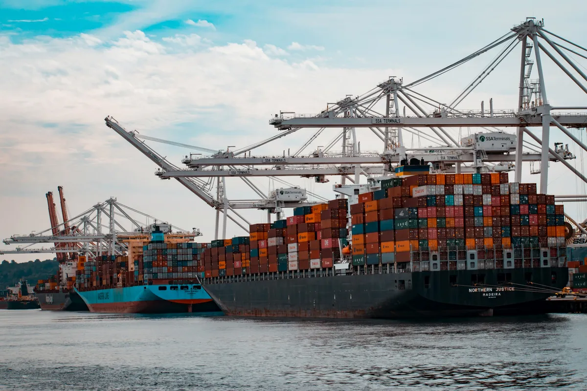 Container ships loading under gantry cranes at a freight terminal - transport and logistics